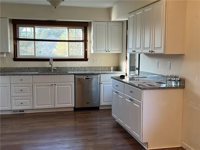 a kitchen with stainless steel appliances kitchen island granite countertop a stove and a sink