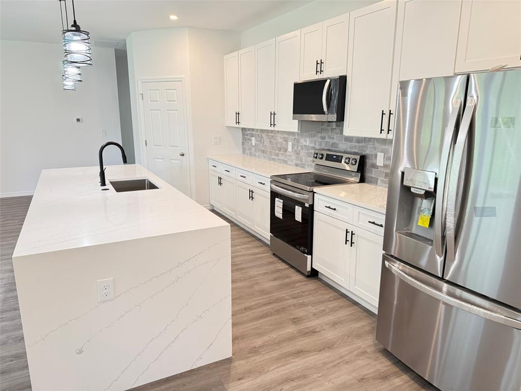 1294 Napoleon Road North Port, FL 34288 - Photo 8 of 25 a kitchen with stainless steel appliances a refrigerator sink and microwave