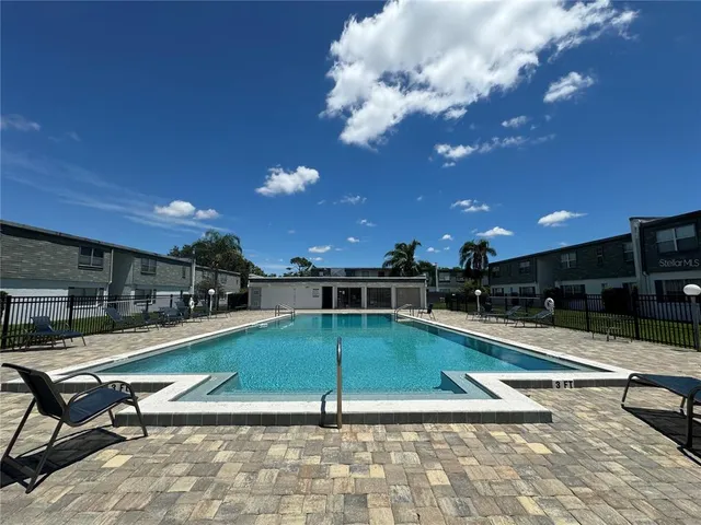 a view of a swimming pool with a lounge chair and tables
