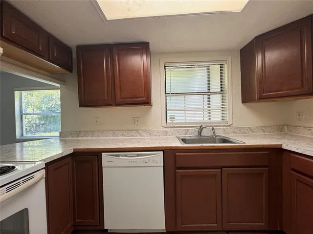 a kitchen with stainless steel appliances granite countertop cabinets sink and window