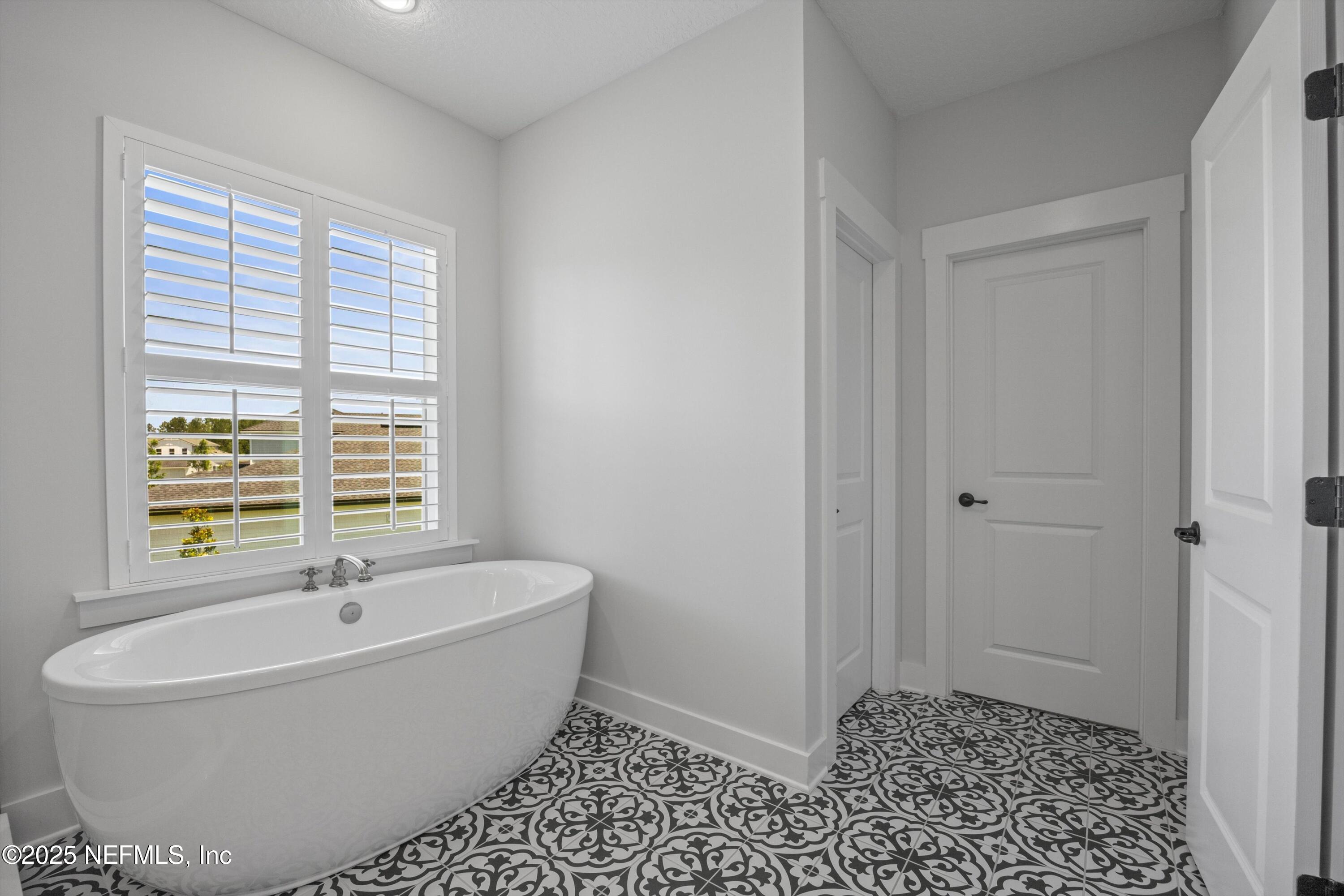 86 Sunset Ridge Court St. Johns, FL 32259 - Photo 32 of 66 a white bath tub sitting in a bathroom next to a window