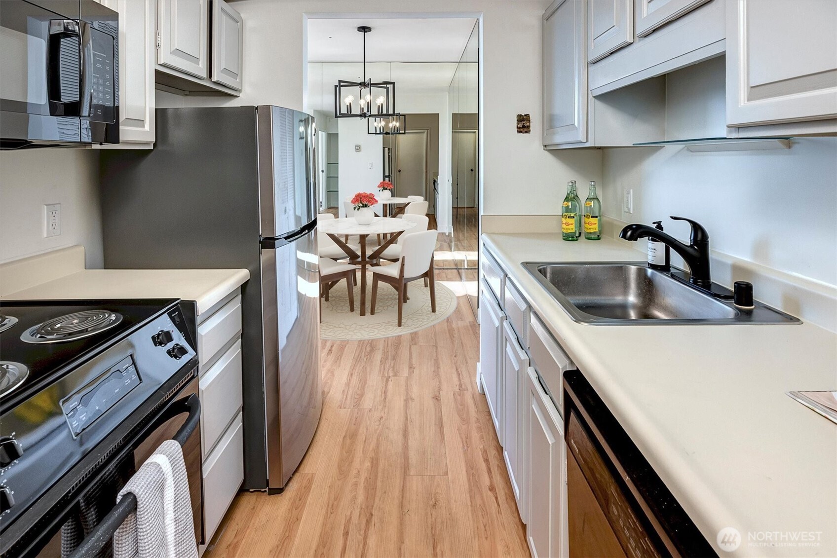 2201 3rd Avenue, Unit 803 Seattle, WA 98121 - Photo 8 of 26 a kitchen with stainless steel appliances granite countertop a refrigerator a sink a stove and a wooden floors