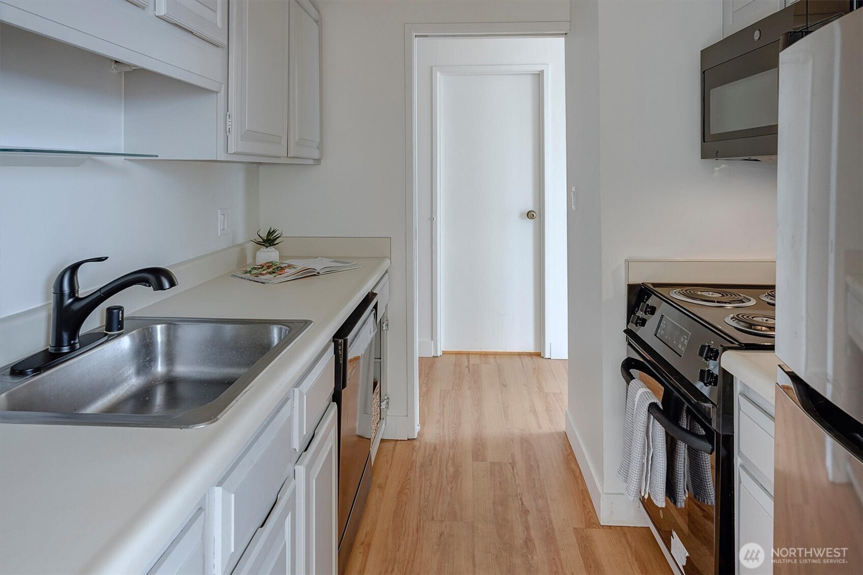2201 3rd Avenue, Unit 803 Seattle, WA 98121 - Photo 10 of 26 a kitchen with sink cabinets and wooden floor