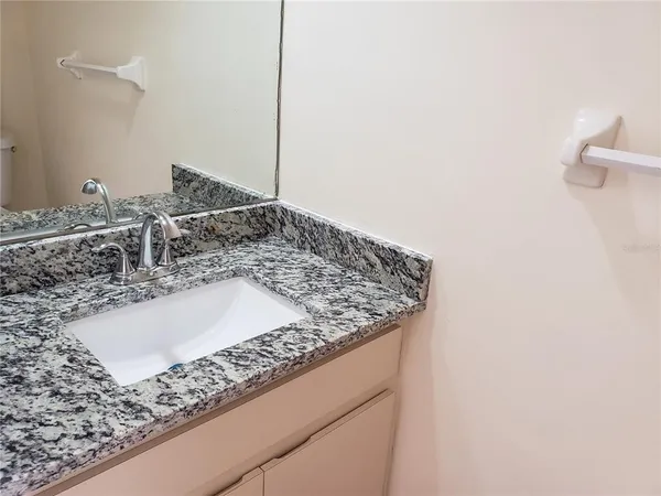 a bathroom with a granite countertop sink and a white stove