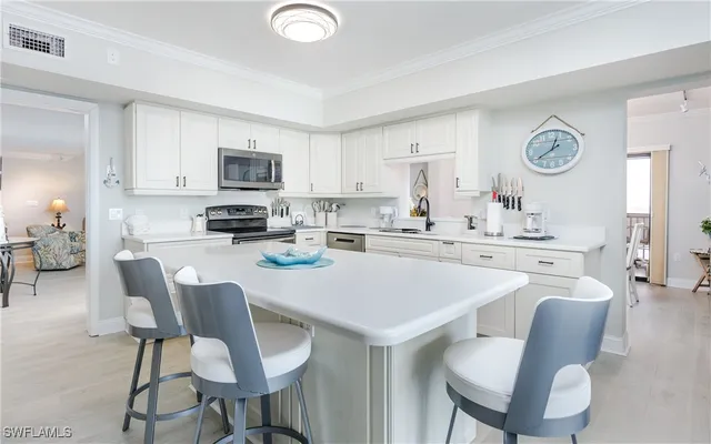 a kitchen with stainless steel appliances granite countertop a stove a table and chairs