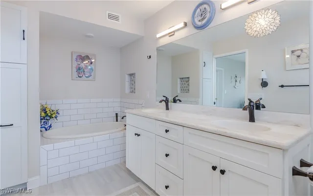 a bathroom with a tub sink and mirror