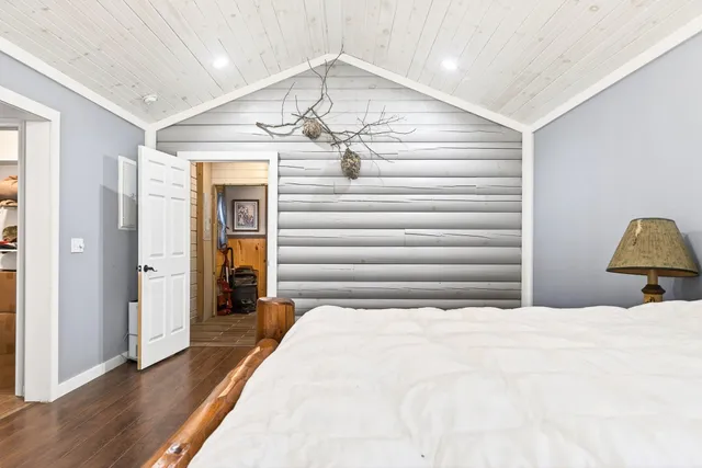a bedroom with bed and wooden floor