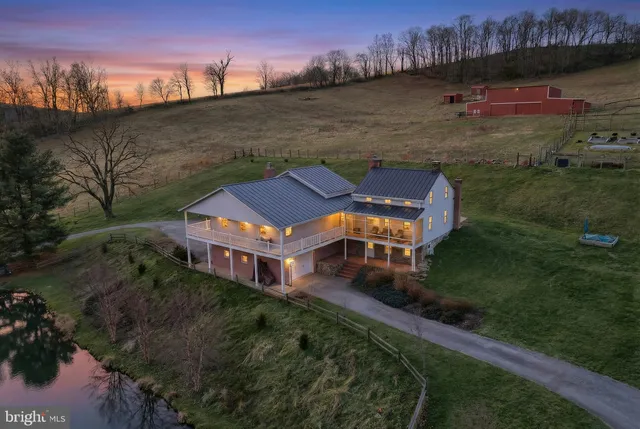 a aerial view of a house with a garden and lake view