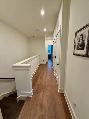 a view of a hallway with wooden floor and staircase