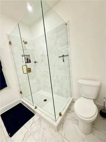 a bathroom with a toilet and a shower