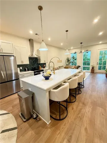 a kitchen with sink a refrigerator and chairs