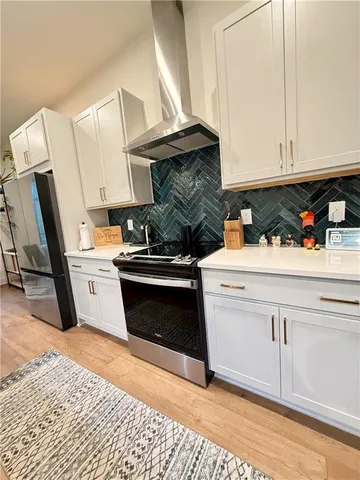 a kitchen with stainless steel appliances kitchen island granite countertop a sink stove and cabinets