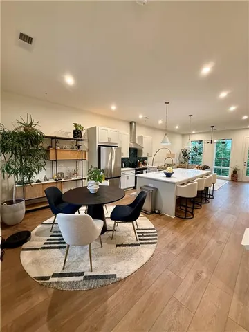 a living room with furniture kitchen view and a potted plant