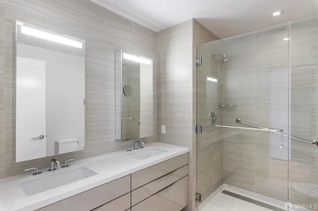 a bathroom with a shower sink and mirror