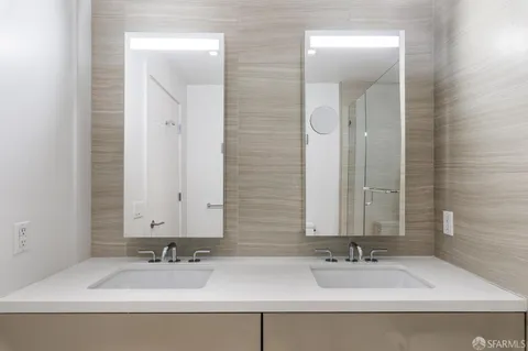 a bathroom with double vanity sinks and a mirror