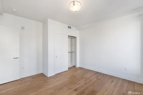a view of a room with wooden floor and white walls
