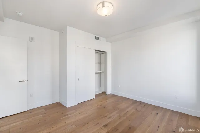 a view of a room with wooden floor and white walls