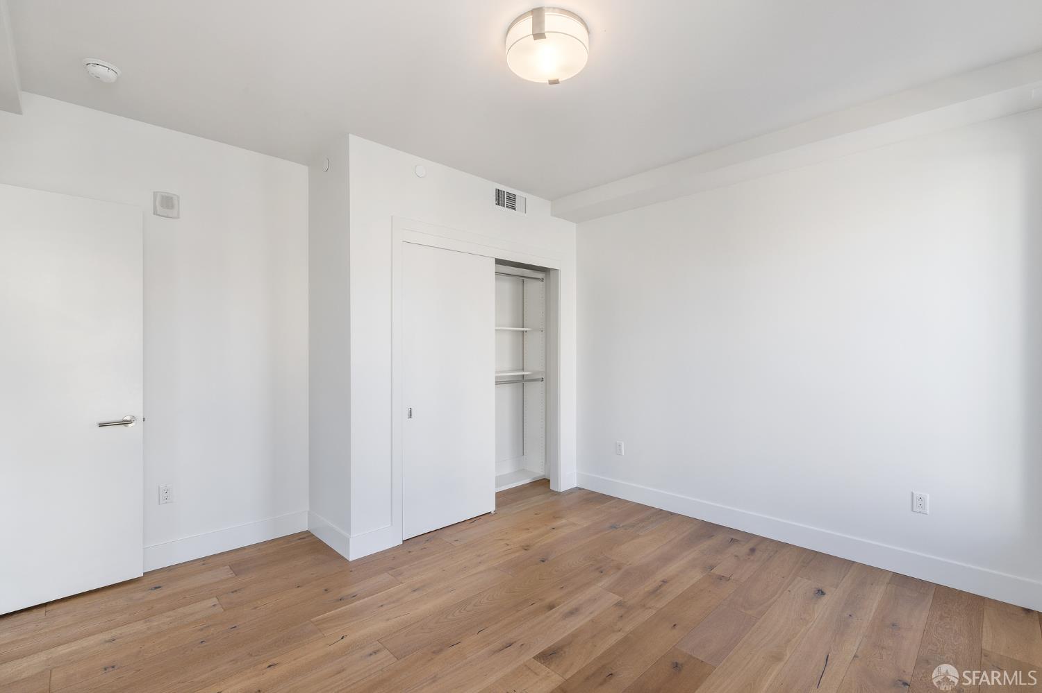 1450 Franklin Street, Unit 701 San Francisco, CA 94109 - Photo 14 of 20 a view of a room with wooden floor and white walls