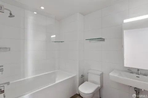 a white toilet sitting next to a bath tub