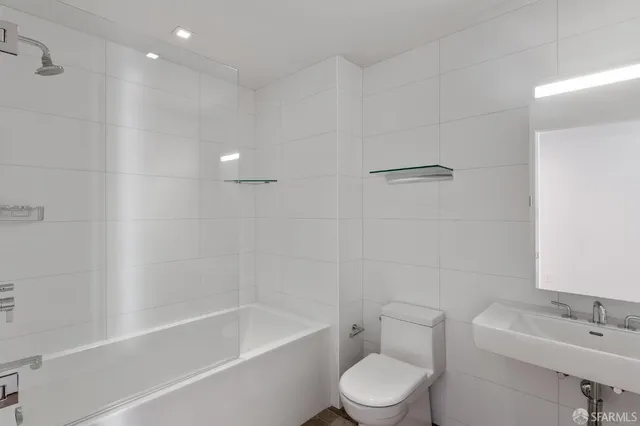 a white toilet sitting next to a bath tub