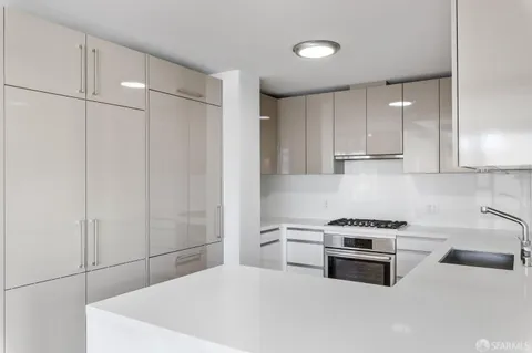 a kitchen with stainless steel appliances a white stove top oven and cabinets
