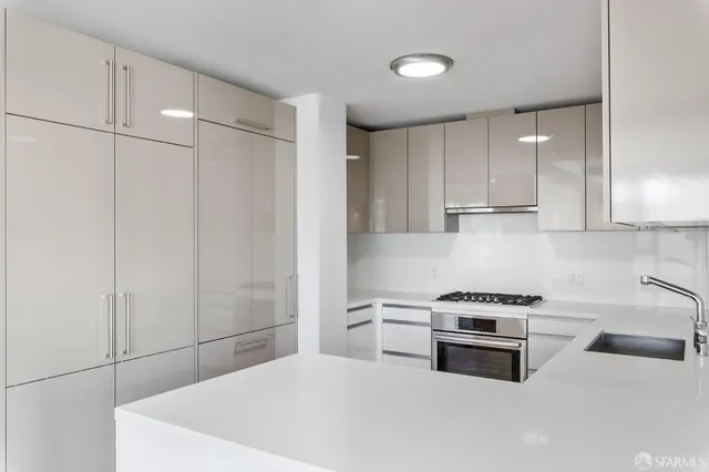 a kitchen with stainless steel appliances a white stove top oven and cabinets