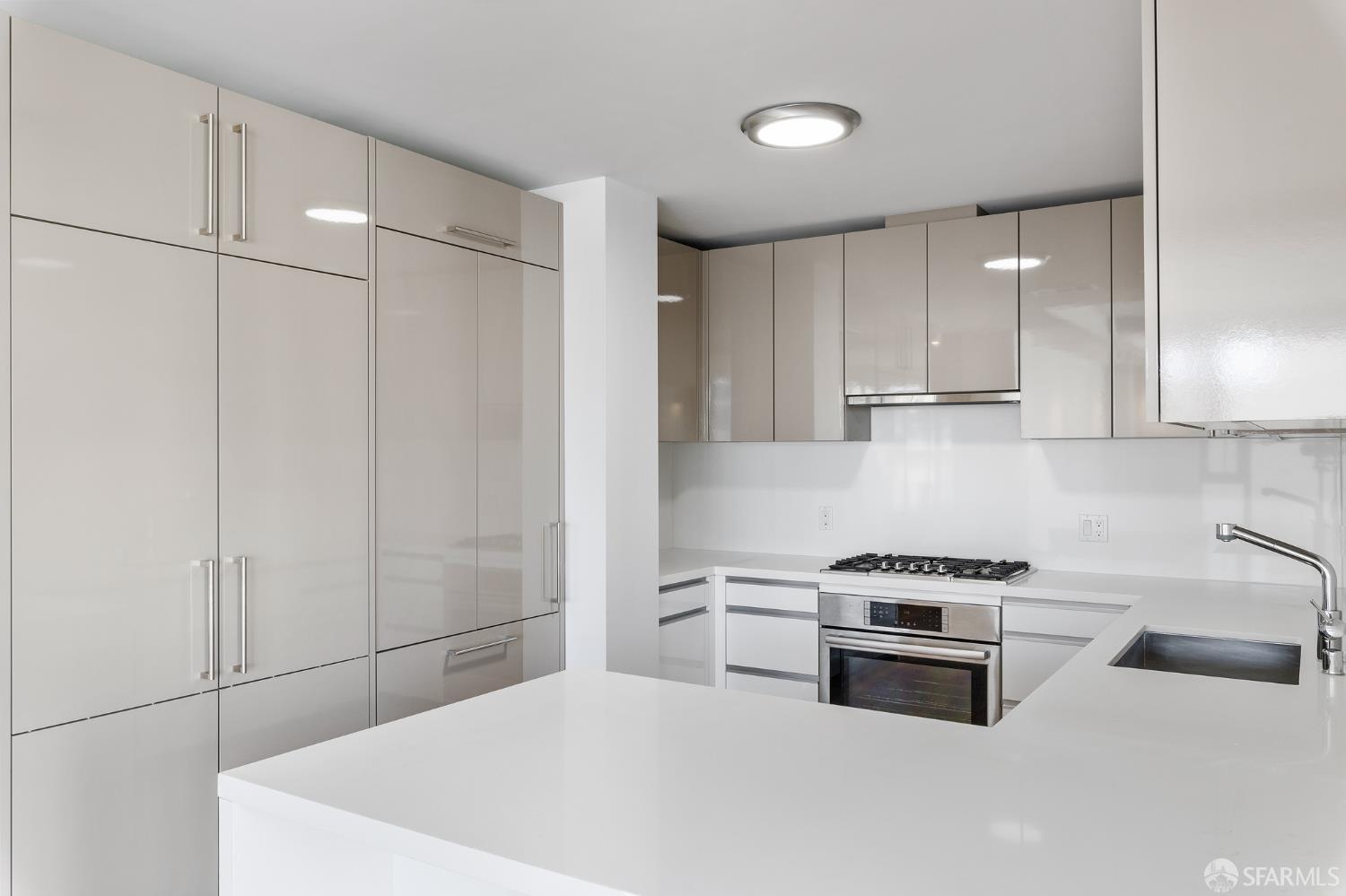 1450 Franklin Street, Unit 701 San Francisco, CA 94109 - Photo 5 of 20 a kitchen with stainless steel appliances a white stove top oven and cabinets