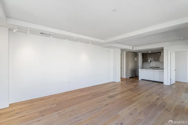 a view of empty room with wooden floor and cabinet
