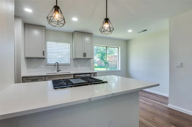 a kitchen with stainless steel appliances granite countertop a sink and a stove