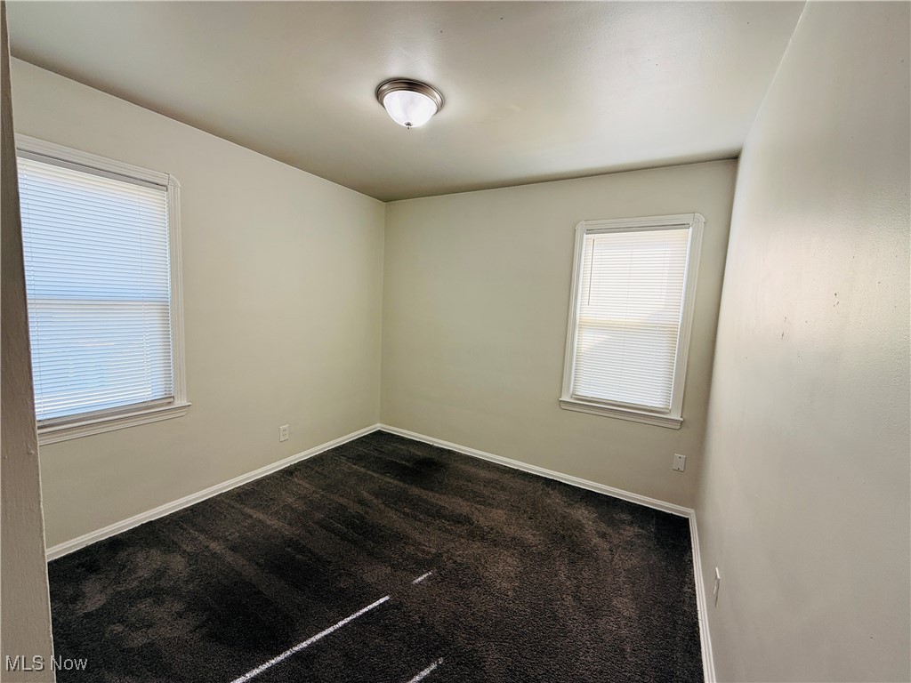 5239 Arch Street Maple Heights, OH 44137 - Photo 8 of 25 Empty room with dark colored carpet and baseboards