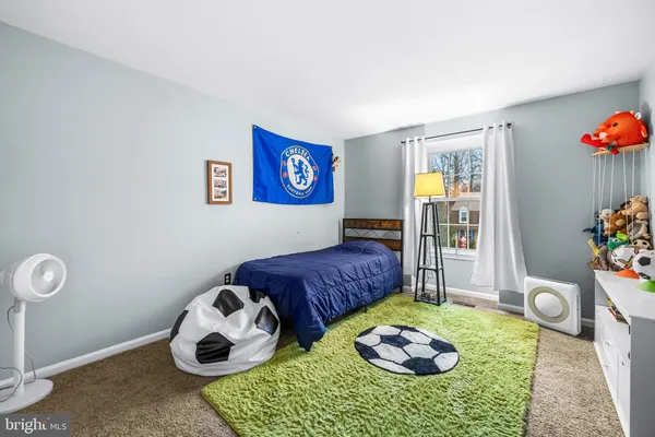 a bedroom with a bed and a painting on the wall
