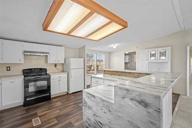 a kitchen with stainless steel appliances a stove a refrigerator and a white cabinets