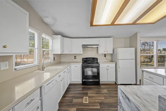 a kitchen with a cabinets wooden floor and a window