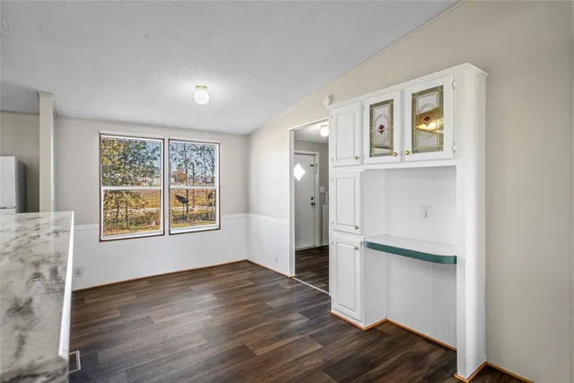 a view of a hallway with wooden floor and cabinet