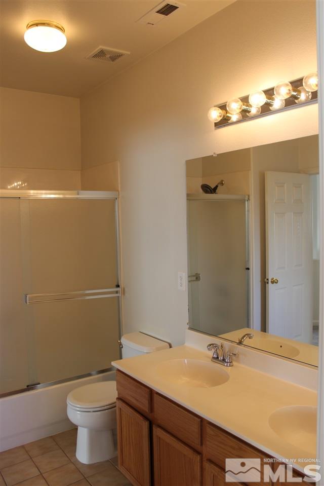 10409 Summershade Lane Reno, NV 89521 - Photo 15 of 22 a bathroom with a granite countertop sink toilet and a mirror