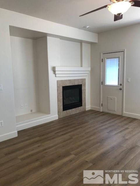 10409 Summershade Lane Reno, NV 89521 - Photo 6 of 22 an empty room with wooden floor fireplace and windows