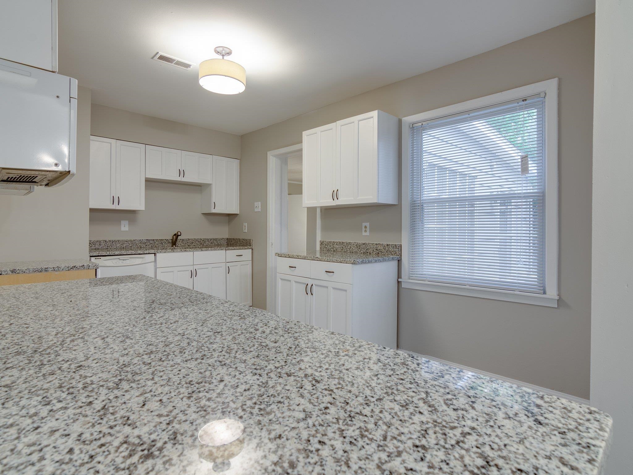 450 Homeville Road Collierville, TN 38017 - Photo 3 of 17 Kitchen featuring light stone countertops, white cabinets, and white dishwasher
