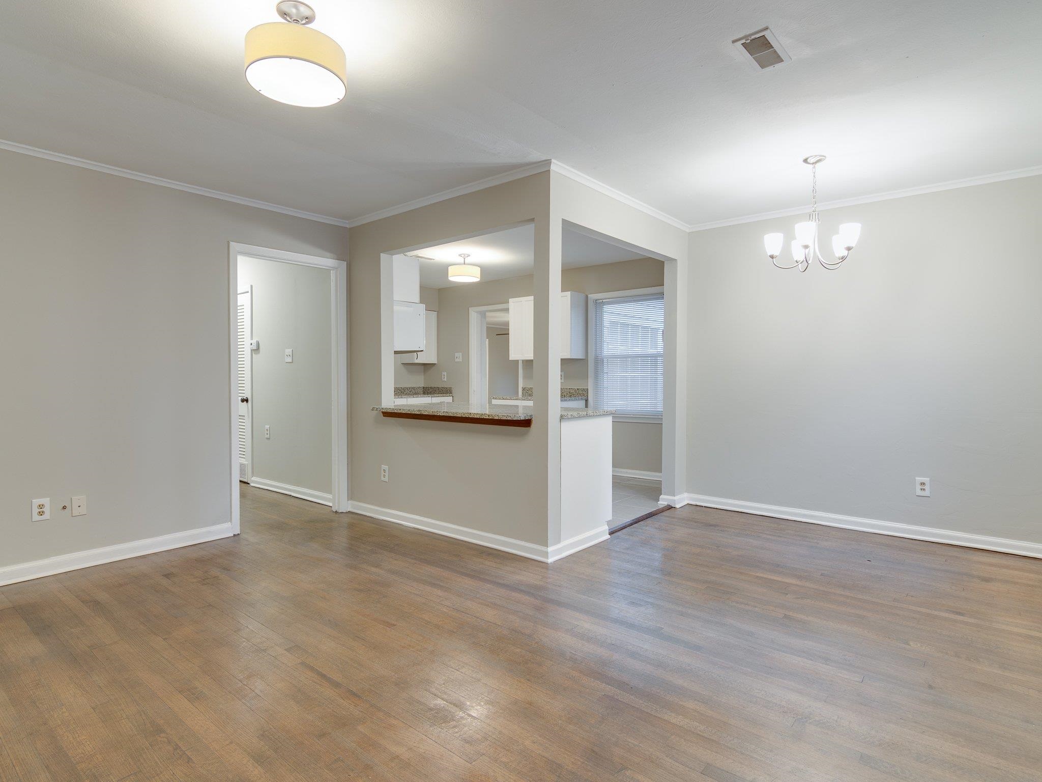 450 Homeville Road Collierville, TN 38017 - Photo 4 of 17 Unfurnished room with crown molding, dark wood-style floors, and hanging lights