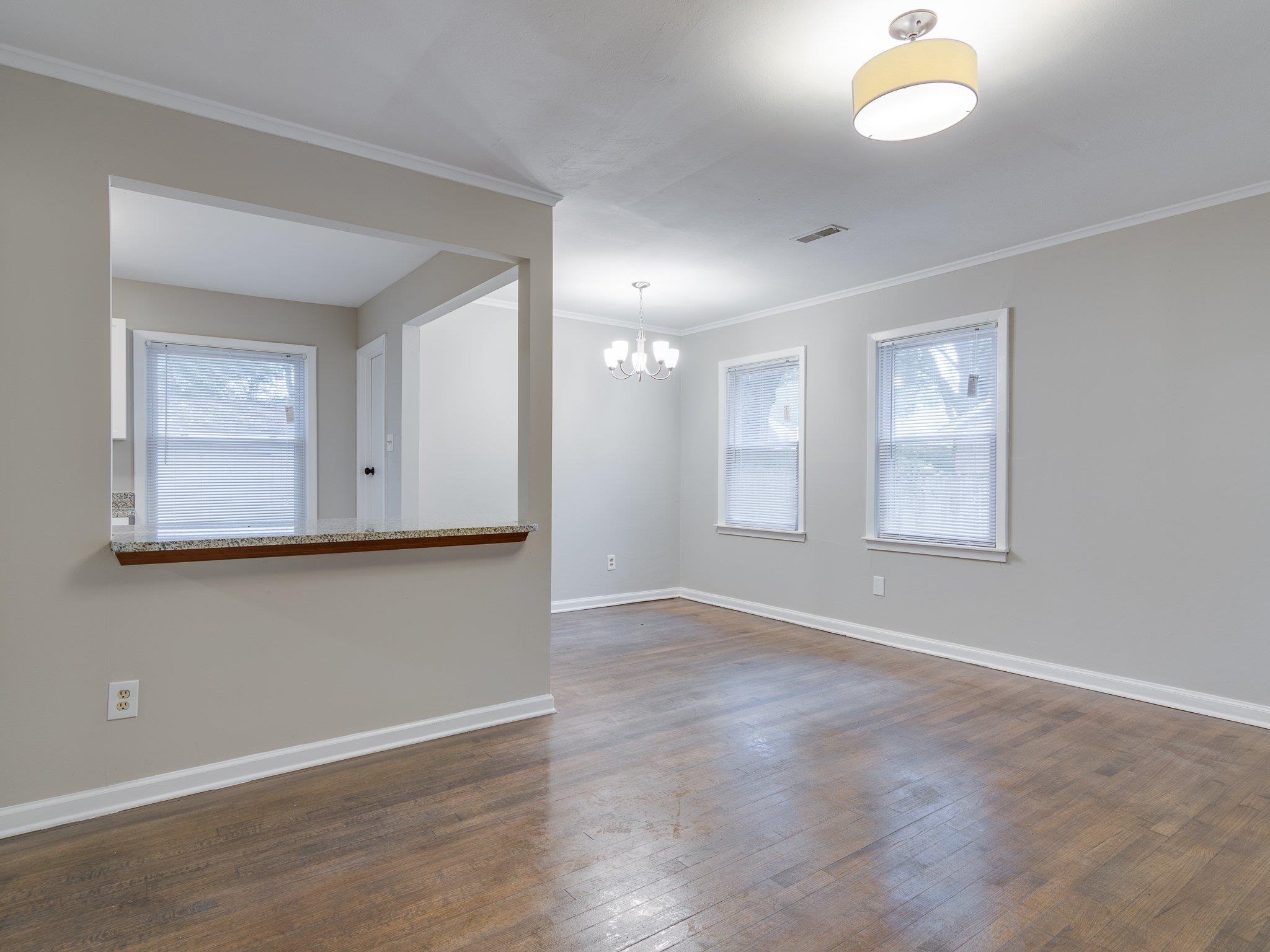 450 Homeville Road Collierville, TN 38017 - Photo 6 of 17 Unfurnished room with dark wood finished floors, a chandelier, plenty of natural light, and ornamental molding