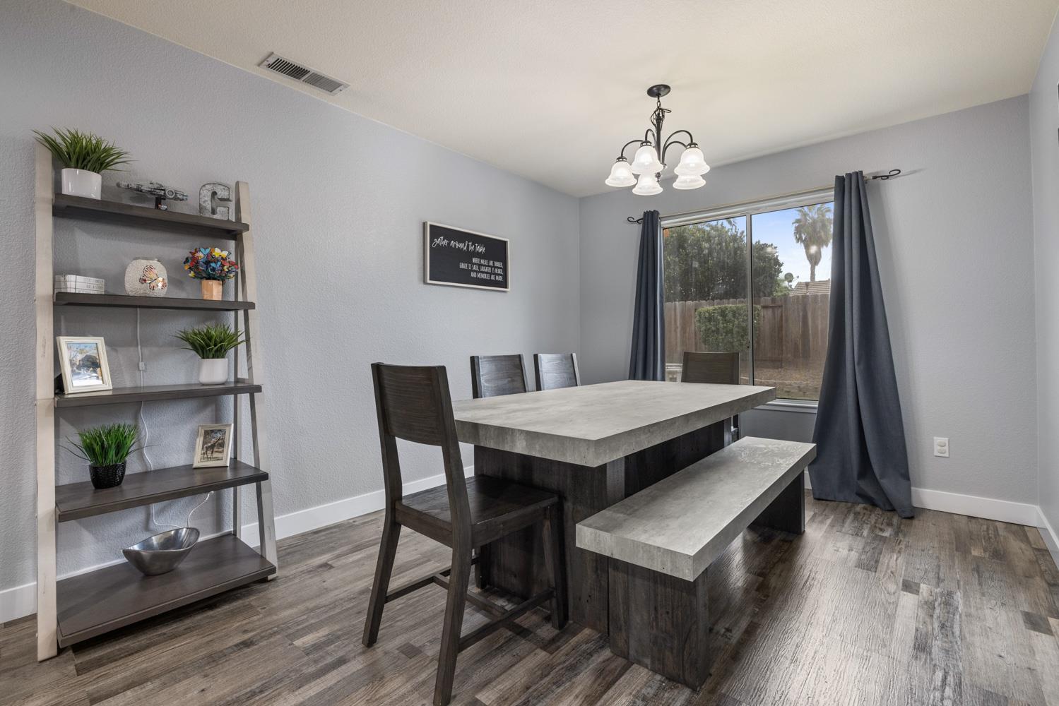 818 Travaille Way Ripon, CA 95366 - Photo 14 of 52 a view of a dining room with furniture wooden floor and a chandelier