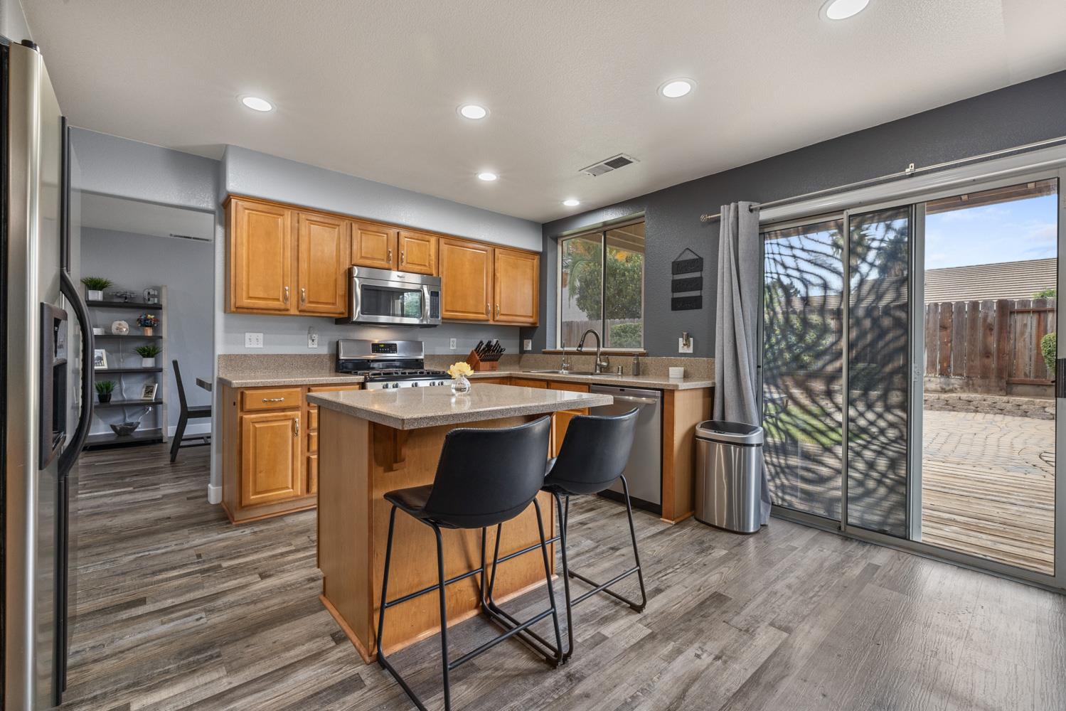 818 Travaille Way Ripon, CA 95366 - Photo 17 of 52 a kitchen with stainless steel appliances kitchen island granite countertop a stove a sink and a refrigerator