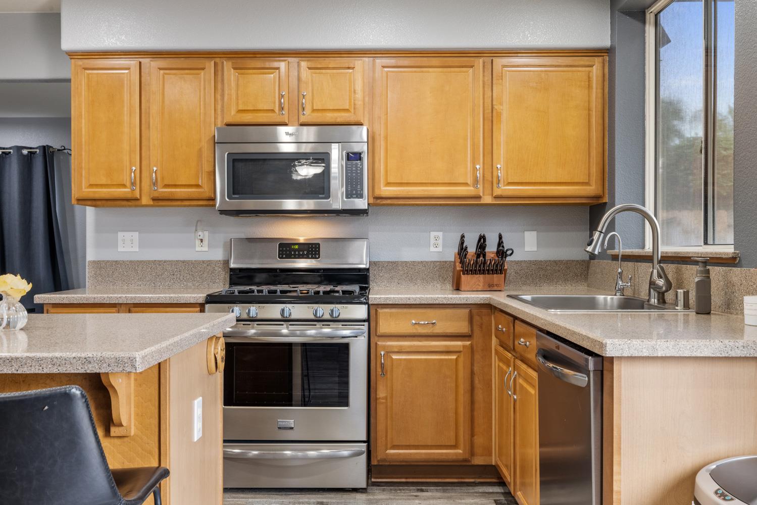818 Travaille Way Ripon, CA 95366 - Photo 18 of 52 a kitchen with stainless steel appliances granite countertop a stove a sink and a microwave