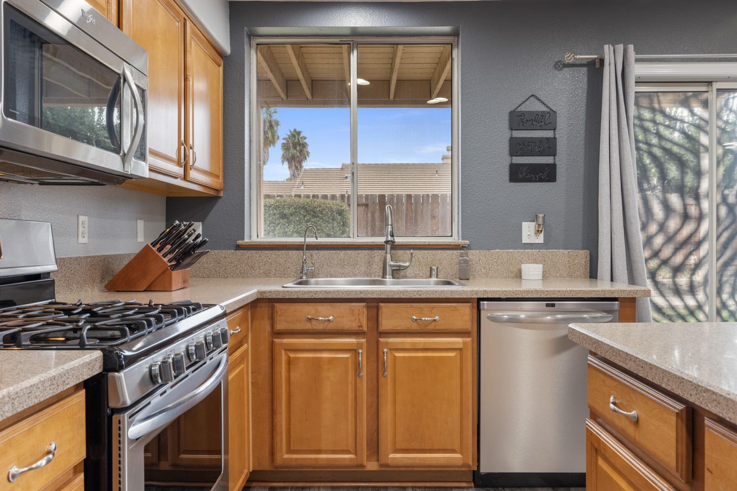 818 Travaille Way Ripon, CA 95366 - Photo 20 of 52 a kitchen with stainless steel appliances granite countertop a stove and a sink
