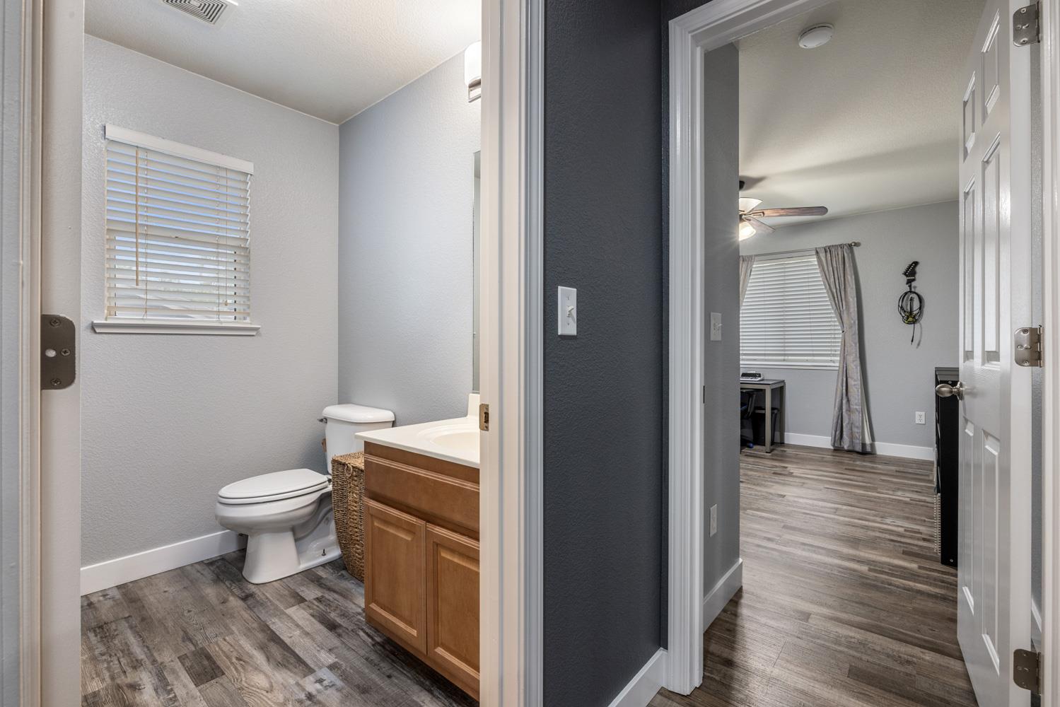 818 Travaille Way Ripon, CA 95366 - Photo 36 of 52 a bathroom with a toilet sink and a wooden floor