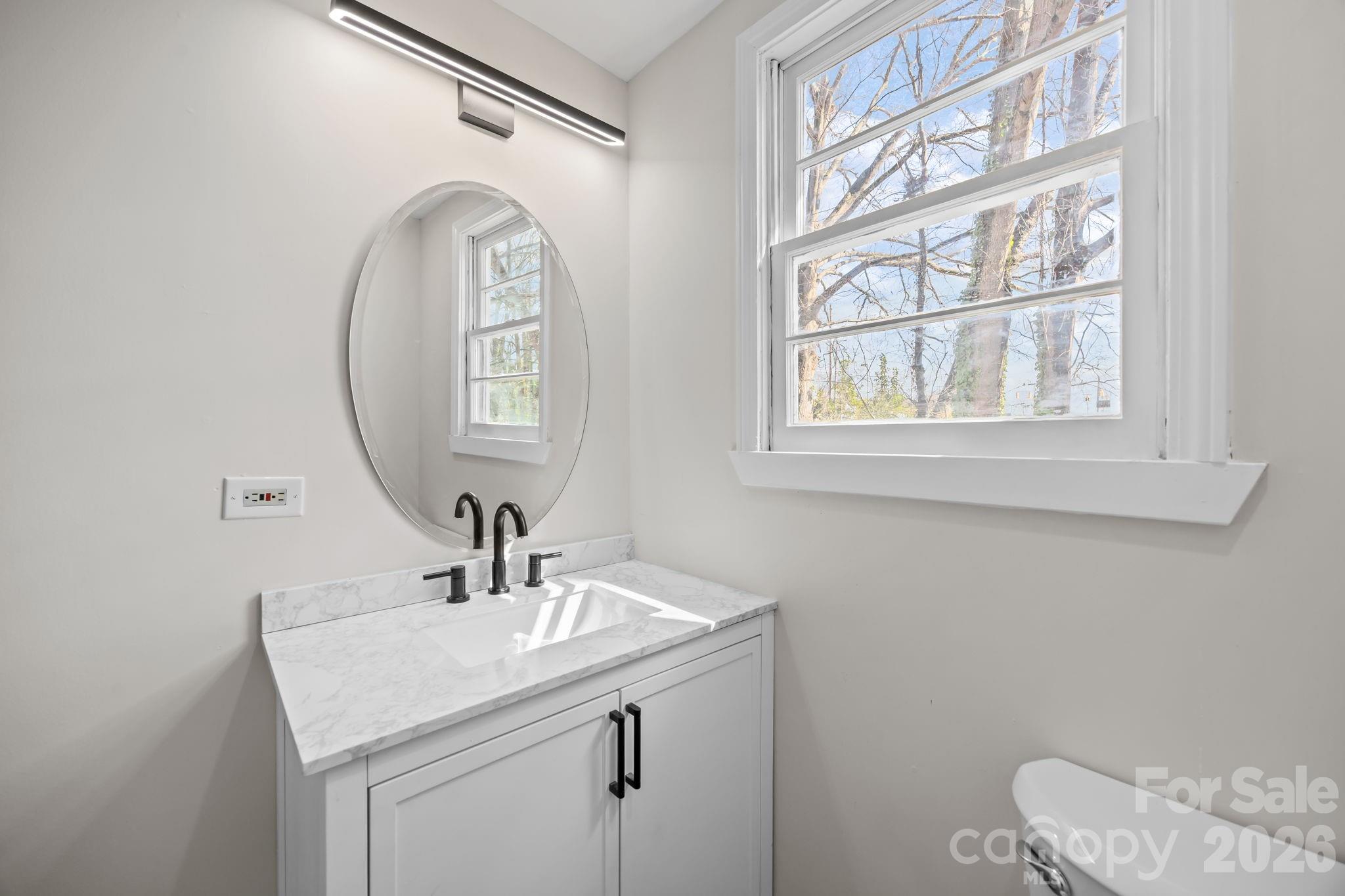 511 East Trade Street Dallas, NC 28034 - Photo 12 of 16 a bathroom with a sink and a mirror