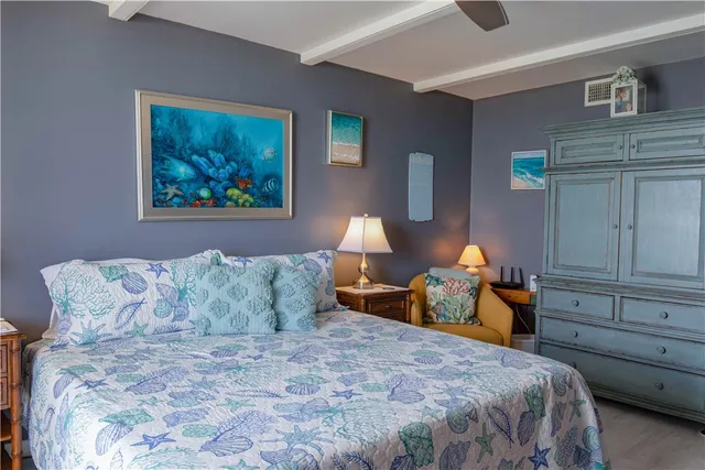 a bedroom with a bed a dresser and with potted plants