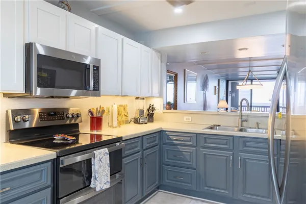 a kitchen with stainless steel appliances granite countertop a refrigerator and a sink