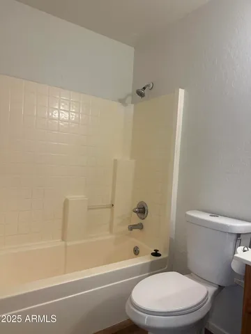 a white toilet and tub next to a bathroom sink