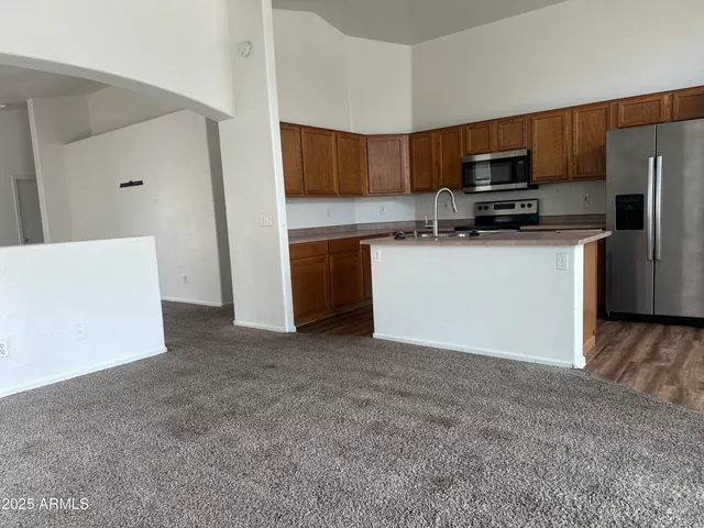 a kitchen with stainless steel appliances a refrigerator a stove a microwave and cabinets