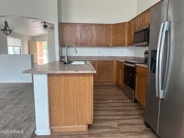a kitchen with kitchen island granite countertop a sink stove and refrigerator